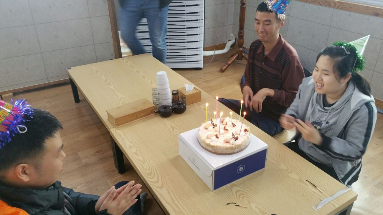 주간보호센터 4분기 생일자들이 케이크에 초를 붙이고 축하하고 있는 모습