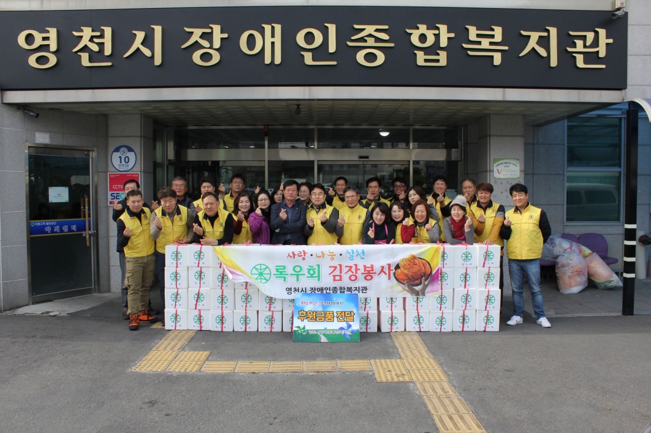 김장김치를 후원하고 단체사진을 찍고 있는 록우회 회원들과 관장 모습